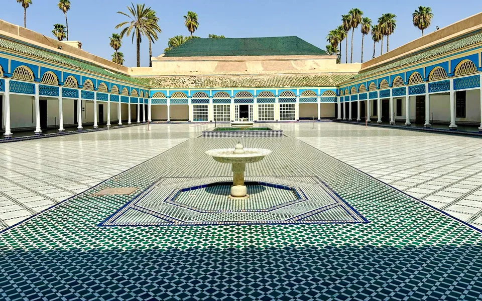 Wide view of the Bahia Palace courtyard with arcades and palm trees