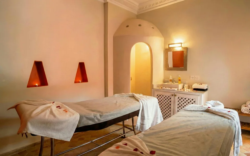 Massage beds and folded towels in a softly lit spa room